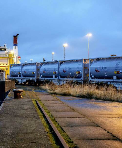 Photo: A train with DeuCon containers rolls onto a ferry at dusk